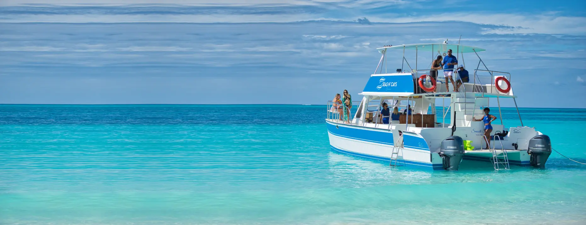 Guests aboard a Seas N' Cays catamaran on the turquoise water off Nassau, Bahamas